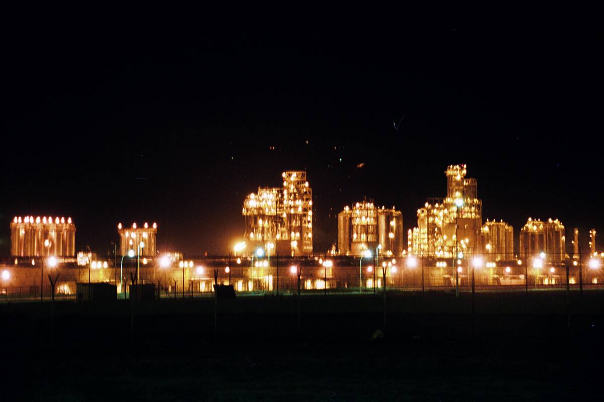 Petrochemical processing units illuminated at night in the Al Ahmadi industrial area
